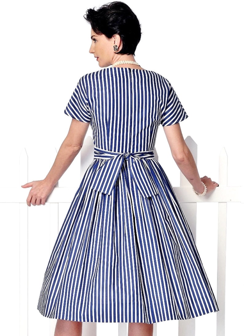 May include: A blue and white striped dress with a fitted bodice and a full skirt. The dress has a tie belt at the waist and short sleeves.