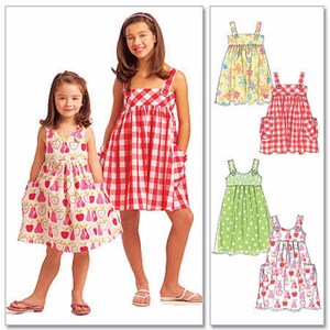 May include: A sewing pattern for a sleeveless dress with pockets. The pattern includes four different fabric options: a floral print, a red and white gingham, a green polka dot, and a pink and white fruit print.