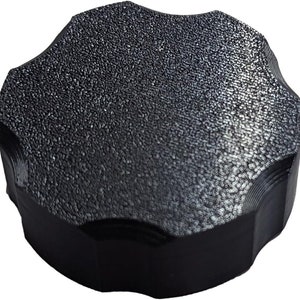 May include: Black plastic knob with a textured surface and a star-shaped design.