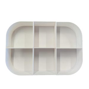 May include: White plastic organizer with six compartments. The organizer is oval shaped and has a smooth surface.