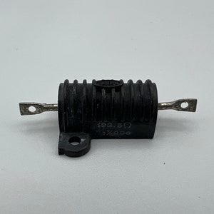May include: A black cylindrical resistor with silver terminals. The resistor has a ribbed body and a small label with the text "193.5Ω" and "1% 03a". The terminals are flat with a hole for mounting.