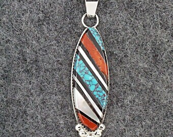 May include: A silver pendant with a multi-colored inlay of turquoise, red coral, black jet, and mother of pearl. The pendant is oval shaped and has a silver bail.