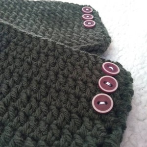 May include: A pair of dark green crocheted wrist warmers with maroon buttons.