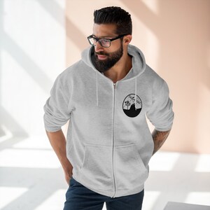 May include: A gray zip-up hoodie with a black circle logo featuring a mountain range and the text "Come Closer".