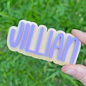May include: A wooden sign with the name "Jillian" written in purple letters.
