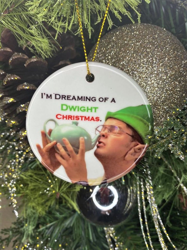Pode incluir: Ornamento de Natal de cer&acirc;mica branca com uma imagem de um homem vestido de duende, segurando um bule e dizendo "Estou sonhando com um Natal de Dwight."