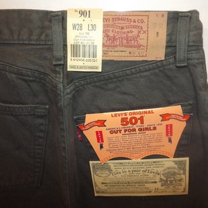 Op de afbeelding: Een donkergroene Levi's 501 jeans met een wit label met de tekst "Levi's Original 501, America's Original Jeans - Since 1873, Cut for Girls, Premium Jeans".