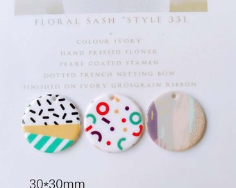 May include: Three round, ivory-colored, hand-pressed flower embellishments with different geometric patterns. Each embellishment is 30mm in diameter and has a small hole at the top for attaching to a ribbon or other craft project. "Floral Sash" "Style 331" "Colour Ivory" "Hand Pressed Flower" "Pearl Coated Stamen" "Dotted French Netting Bow" "Finished on Ivory Grosgrain Ribbon" 30*30mm