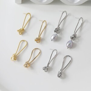 May include: A set of six gold and silver knot earrings. Two of the earrings feature a pearl drop.