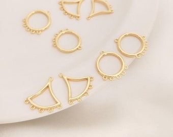 May include: A set of eight gold-toned metal jewelry findings. The findings include four round circles with five small loops around the perimeter and four triangle shapes with five small loops around the bottom edge.