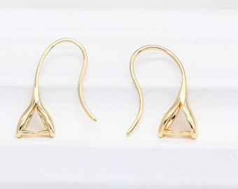 Pode incluir: Um par de descobertas de brincos em tom dourado com uma configuração de forma triangular. As descobertas são projetadas para segurar uma pedra preciosa ou outro adorno.