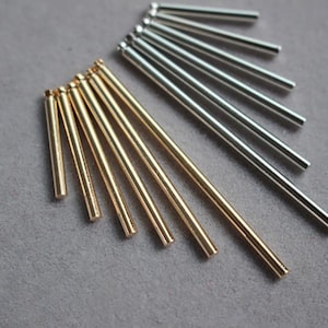 Könnte beinhalten: Ein Satz goldener und silberner Metallstäbe, die in Fächerform angeordnet sind. Die Stäbe sind alle gleich lang und dick.