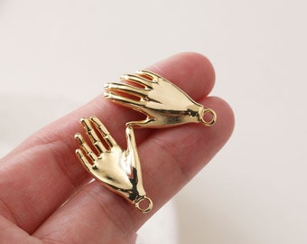 May include: Two gold-toned metal hand charms with a loop for attaching to jewelry or other crafts.