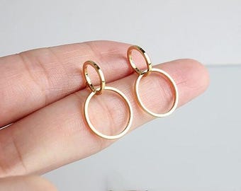 May include: A pair of gold hoop earrings with a smaller hoop inside the larger hoop.