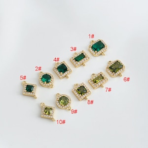 May include: Ten gold-tone connector charms with green and clear crystal accents. The charms are numbered 1 through 10.