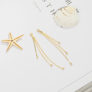 May include: Two gold chain earring dangles with multiple strands and small round jump rings.