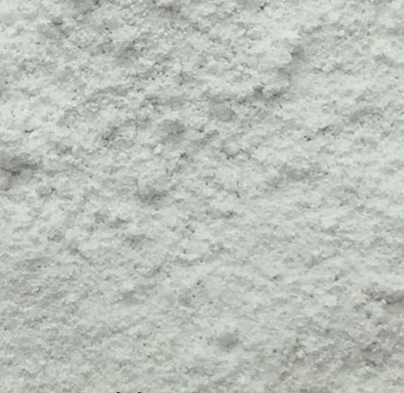 May include: A close-up view of a white powder. The powder is fine and has a slightly grainy texture.