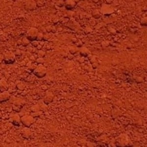 May include: Close-up of a red-brown powder, likely paprika or chili powder, with a slightly grainy texture.