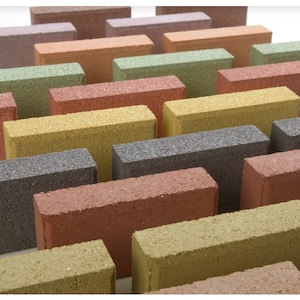 May include: A collection of rectangular concrete pavers in various colors, including red, orange, yellow, green, gray, and brown. The pavers are arranged in a staggered pattern, creating a visually appealing display.