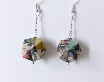 May include: A pair of silver earrings with a geometric, origami-style pendant made from patterned paper. The pendants are black, green, yellow, and pink.