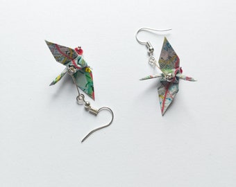 Può includere: Un paio di orecchini origami realizzati con mappe con perline rosse e ganci argentati.