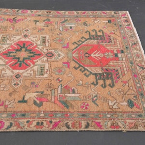 Puede incluir: Una alfombra vintage con un patr&oacute;n geom&eacute;trico en tonos rojos, verdes y beige. La alfombra tiene un borde de flecos y est&aacute; en buen estado.