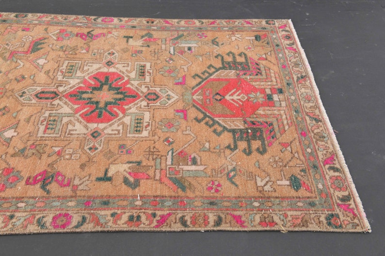 Puede incluir: Una alfombra vintage con un patr&oacute;n geom&eacute;trico en tonos rojos, verdes y beige. La alfombra tiene un borde de flecos y est&aacute; en buen estado.