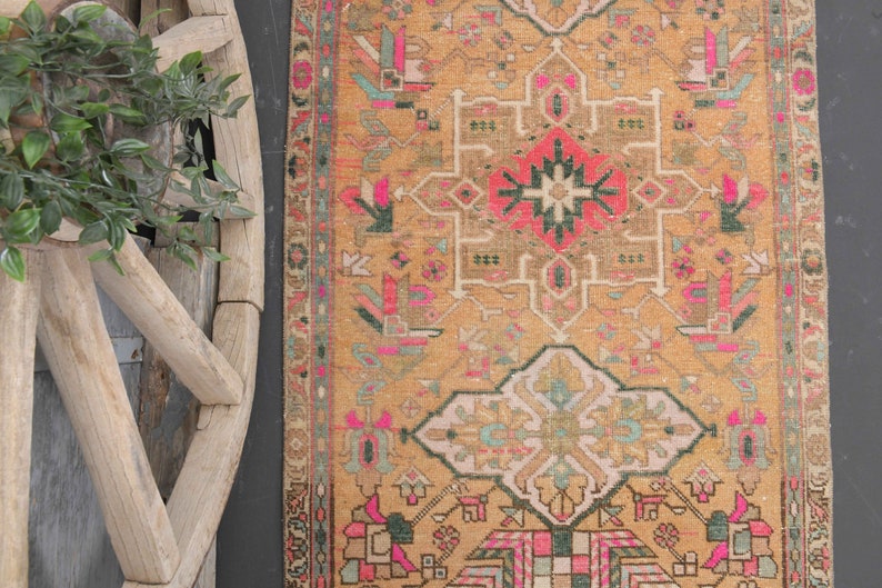 Puede incluir: Una alfombra vintage con un dise&ntilde;o persa tradicional. La alfombra tiene un fondo beige con intrincados patrones en tonos de rosa, verde y negro.