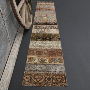 May include: A long, narrow rug with a patchwork design. The rug is made up of several different strips of fabric, each with a unique pattern. The colors in the rug are mostly muted, with shades of brown, beige, and cream. The rug is perfect for adding a touch of vintage charm to any room.