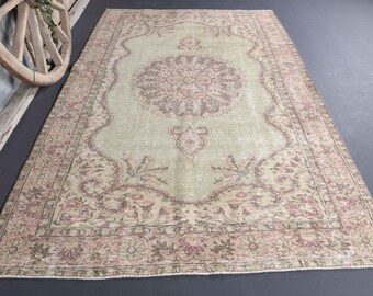 May include: A vintage rug with a light green background and a pink and brown floral pattern. The rug has a distressed look and is perfect for adding a touch of bohemian style to any room.
