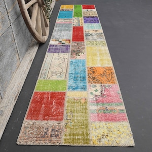 May include: A colourful patchwork runner rug with a variety of patterns and colours, including red, green, blue, yellow and orange.
