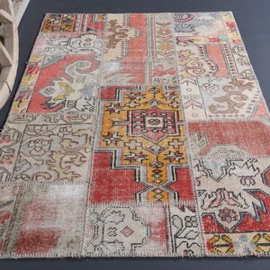 May include: A patchwork rug featuring a mix of colours and patterns, including red, yellow, and blue. The rug is made from various pieces of fabric that have been stitched together.