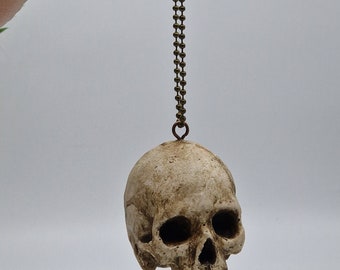 Crâne sur une chaîne. solide petit ornement de demi-crâne humain. Petite réplique en plâtre du crâne humain de Paris.