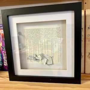 Lesender Origami Elefant aus Buchseite und auf Buchseite mit gestempeltem offenem Buch mit flatternden Seiten in schwarzem 3D-Rahmen