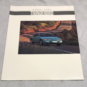 May include: A brochure for the 1994 Ford Thunderbird. The brochure features a photo of a teal blue Thunderbird driving on a winding road.