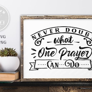 May include: Black and white typography design with the text "Never doubt what one prayer can do" on a white background. The text is in a decorative, handwritten font.