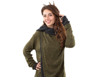 May include: A woman wearing a green and gray hooded sweater with a long, flowing design. The sweater has a relaxed fit and a casual style.