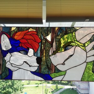 May include: Stained glass panel featuring two anthropomorphic characters. One has blue and white fur with red hair, the other is white and green. The background depicts a forest scene with brown and green hues. The panel is rectangular.