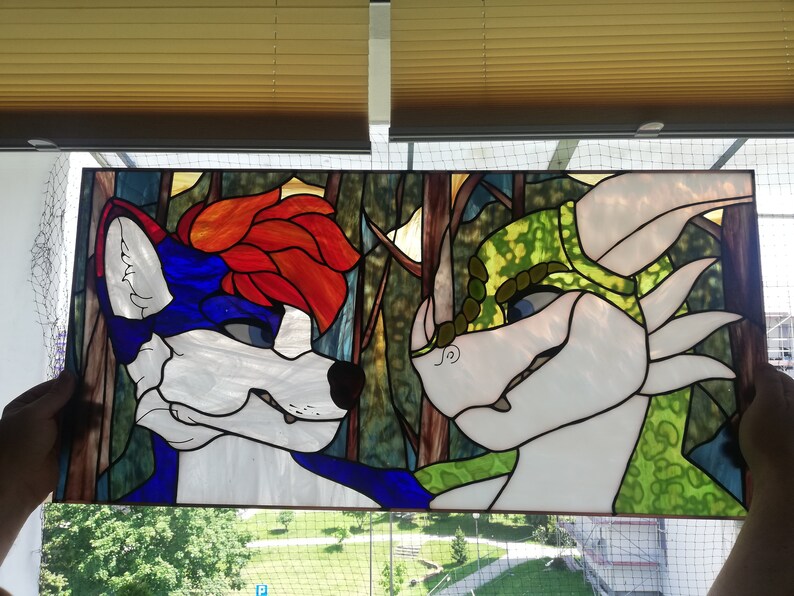 May include: Stained glass panel featuring two anthropomorphic characters. One has blue and white fur with red hair, the other is white and green. The background depicts a forest scene with brown and green hues. The panel is rectangular.