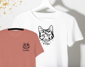 May include: A white t-shirt featuring a black line drawing of a cat face labeled Freya and a dusty rose t-shirt featuring a black line drawing of a cat face labeled Freddie. The text www.myskypet.com, MySkyPet.Etsy.com, and ElonReevesArts.Etsy.com appear.