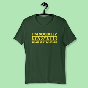 Puede incluir: Una camiseta verde oscuro con el texto "I'm Socially Awkward Please Don't Talk To Me" en amarillo.
