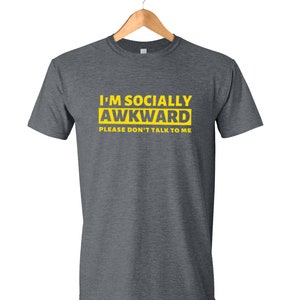 Puede incluir: Una camiseta gris oscuro con el texto "I'm Socially Awkward Please Don't Talk To Me" en amarillo.
