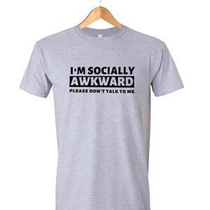 Puede incluir: Una camiseta gris con texto negro que dice "I'm Socially Awkward Please Don't Talk To Me."