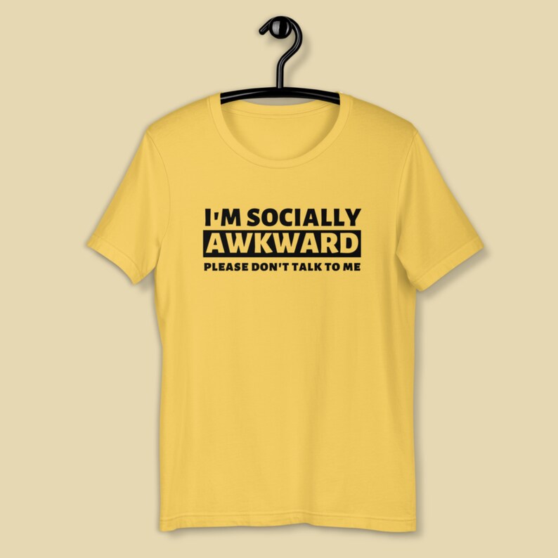 Puede incluir: Camiseta amarilla de manga corta con texto negro que dice "I'm Socially Awkward Please Don't Talk To Me."