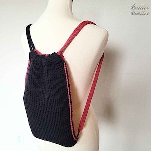 May include: A black drawstring backpack with red trim. The backpack is made of a knitted fabric and has adjustable straps.