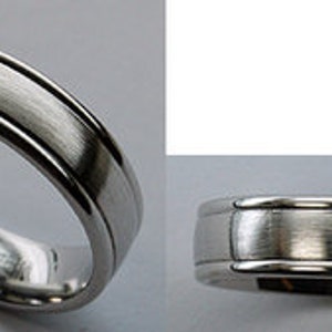 May include: A silver wedding band with a brushed finish and a raised edge.