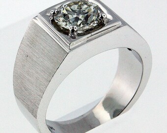 May include: A silver men's ring with a square setting and a large, clear, round diamond.