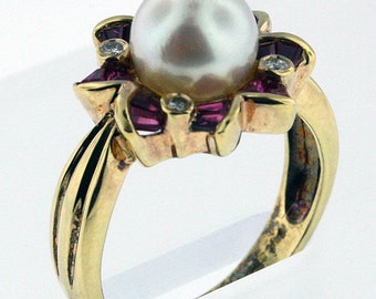 May include: A gold ring with a large white pearl surrounded by a flower design with pink and clear stones.