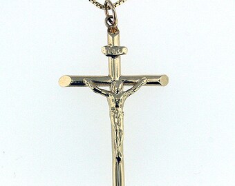 May include: A gold-toned pendant necklace featuring a crucifix with a detailed figure of Jesus Christ. The pendant is attached to a delicate gold chain.