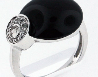 May include: A silver ring with a black oval gemstone and a circle of smaller white gemstones.